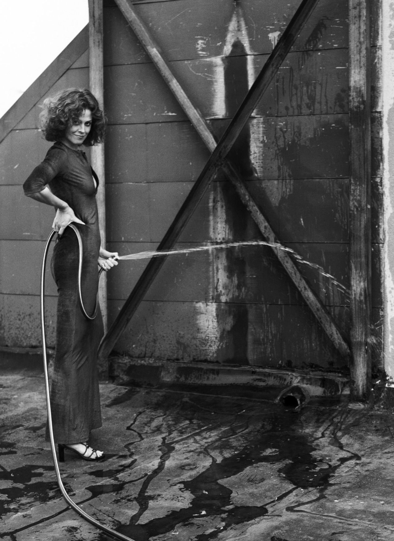 Wallpaper, actress, brunette, long hair, Sigourney Weaver, dress, film grain, old photo, Helmut Newton, smiling, hose, women outdoors, high heels, monochrome, portrait display, water, hands on hips, wall 1280x1757