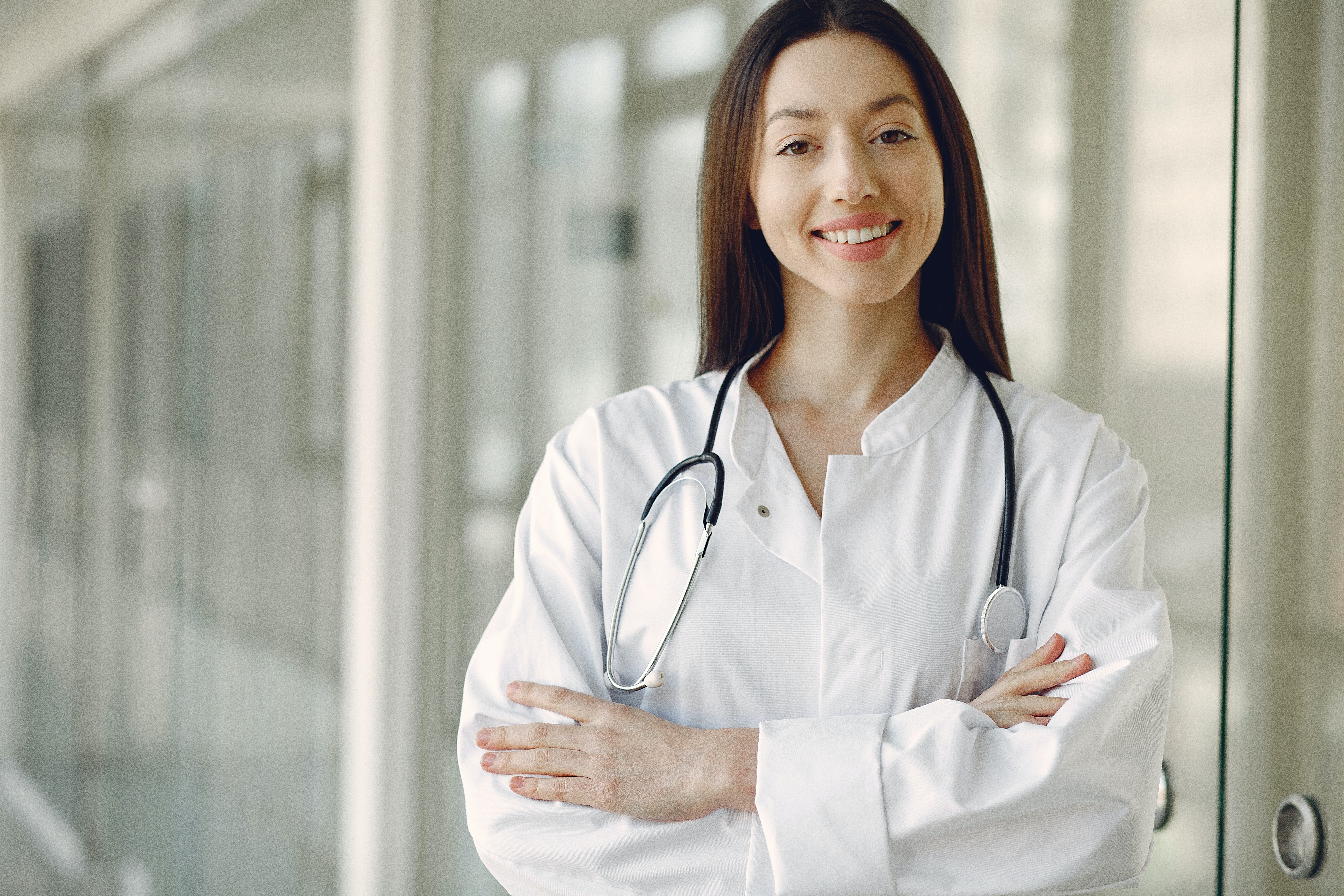 Crop doctor in medical uniform with stethoscope standing in clinic corridor · Free