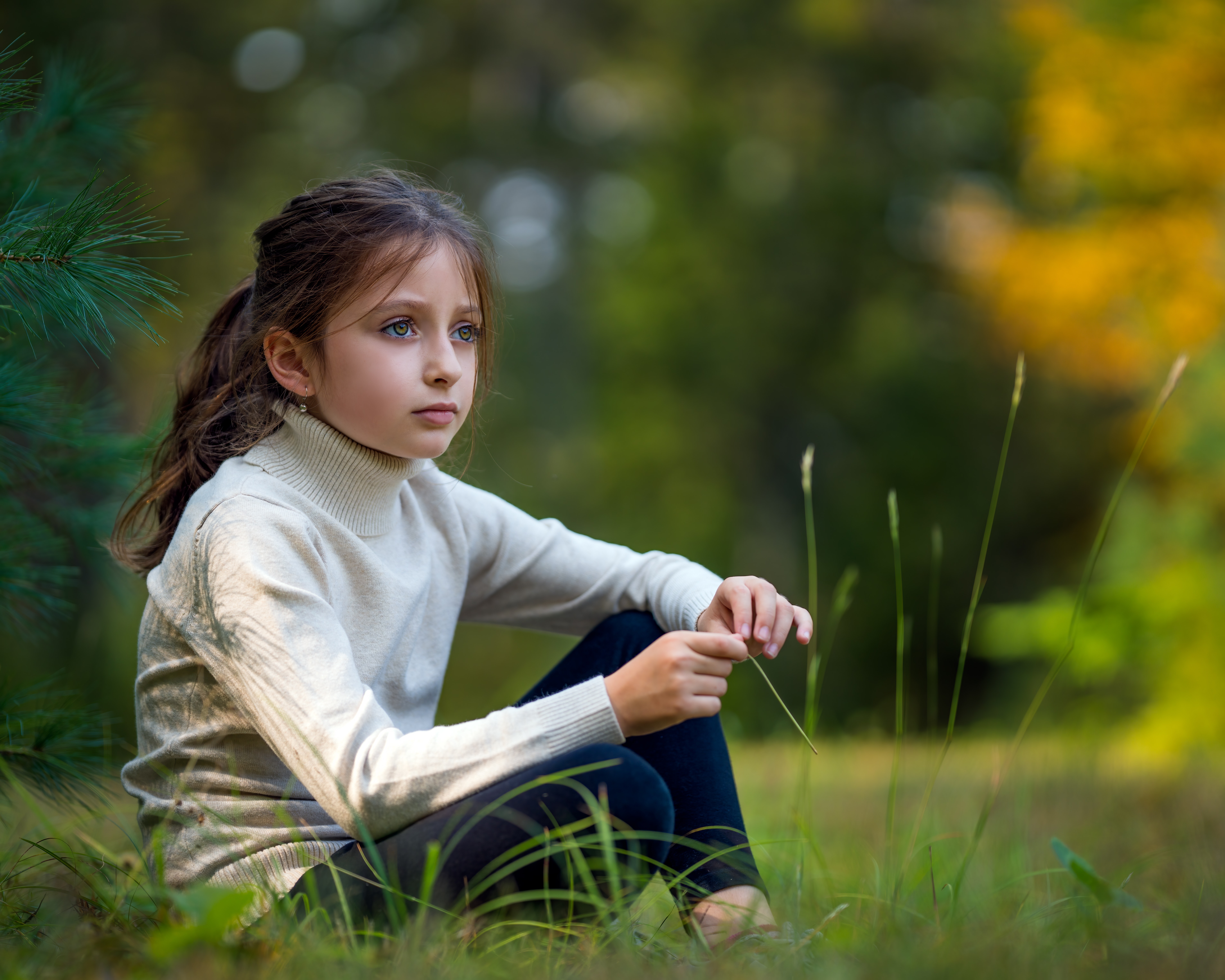 Cute girl sitting on lush meadow in nature · Free