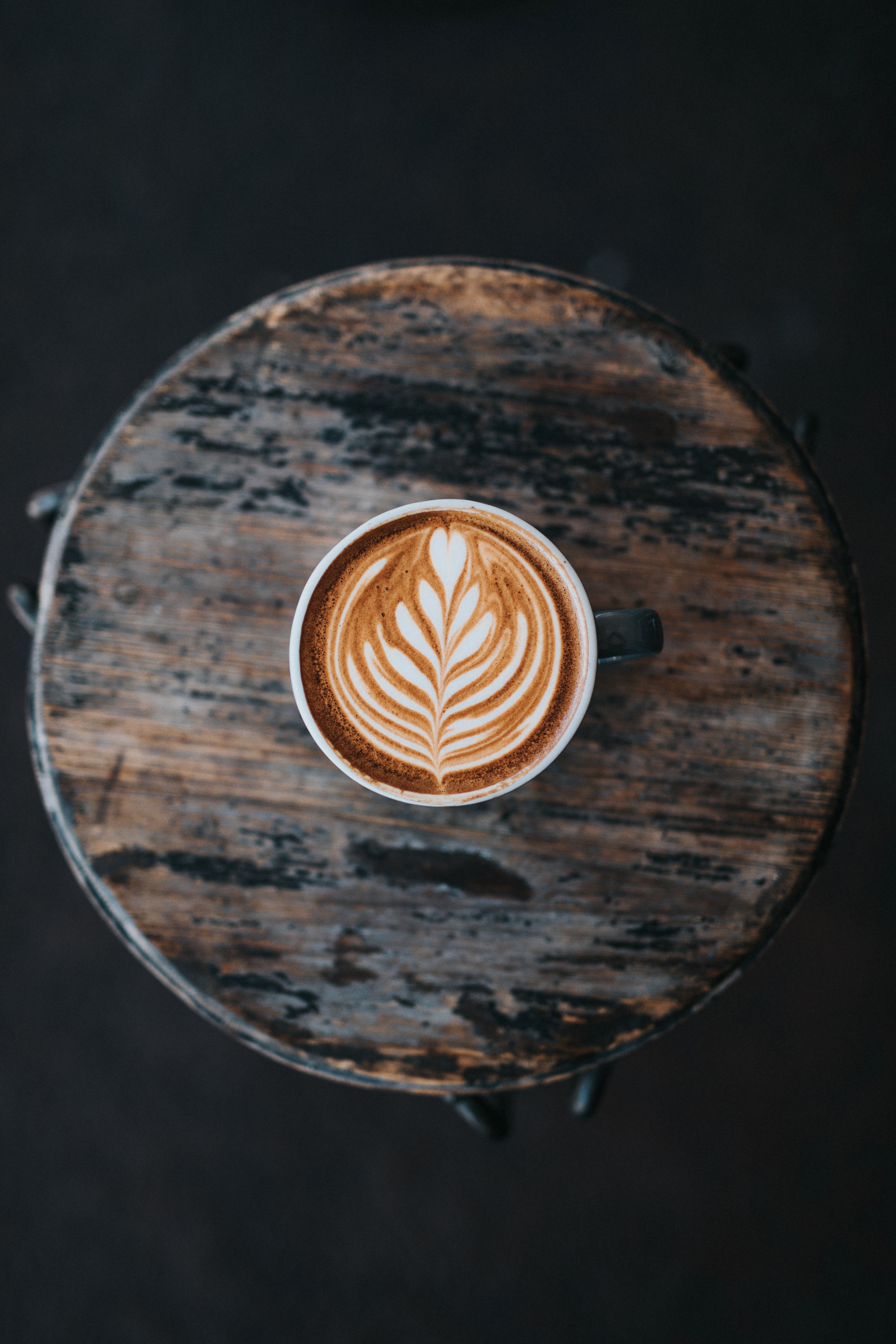 Wallpaper / coffee latte art viewed from above in a cup on the wooden table at two guns espresso, espresso with latte art 4k wallpaper