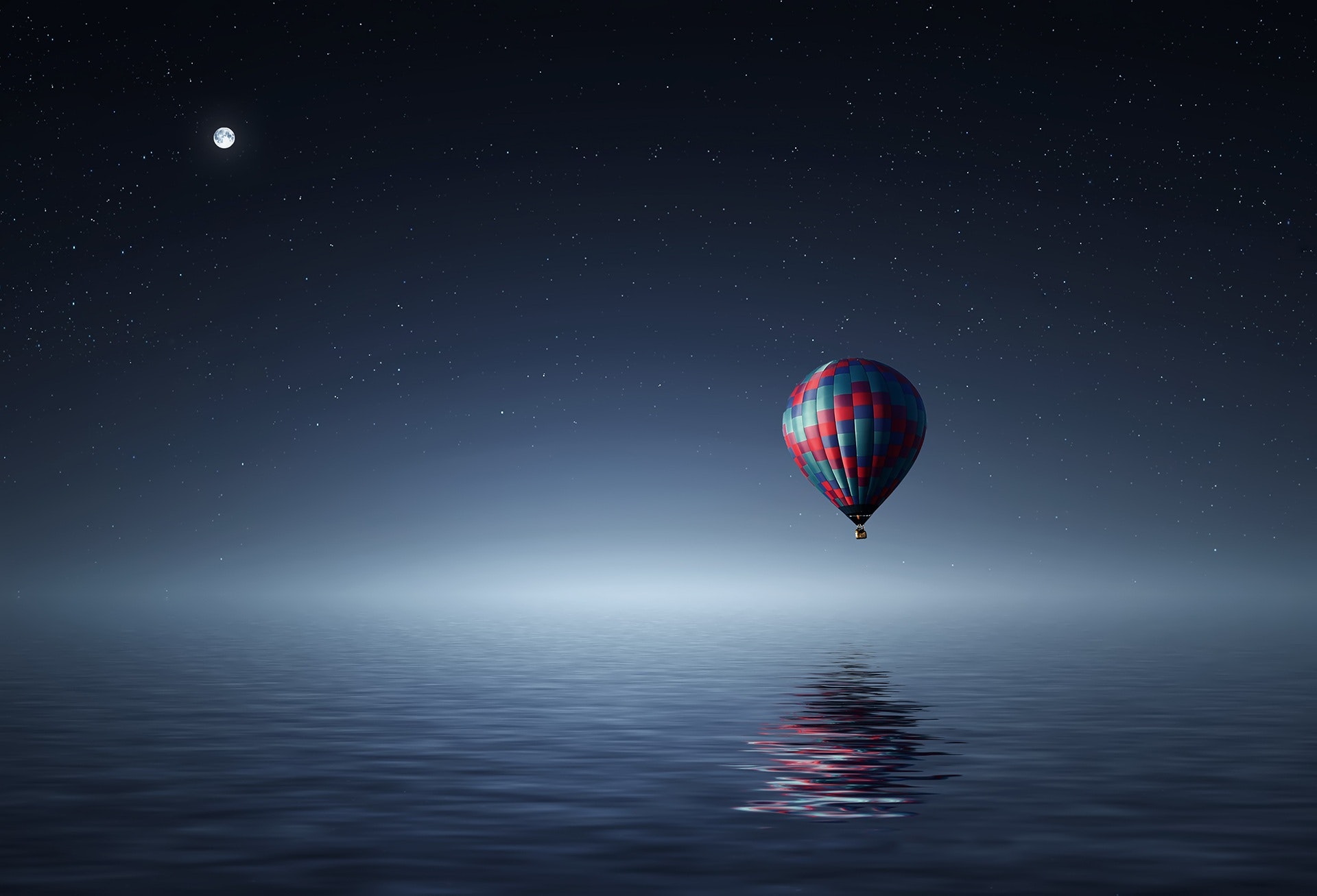 Red and Blue Hot Air Balloon Floating on Air on Body of Water during Night Time · Free