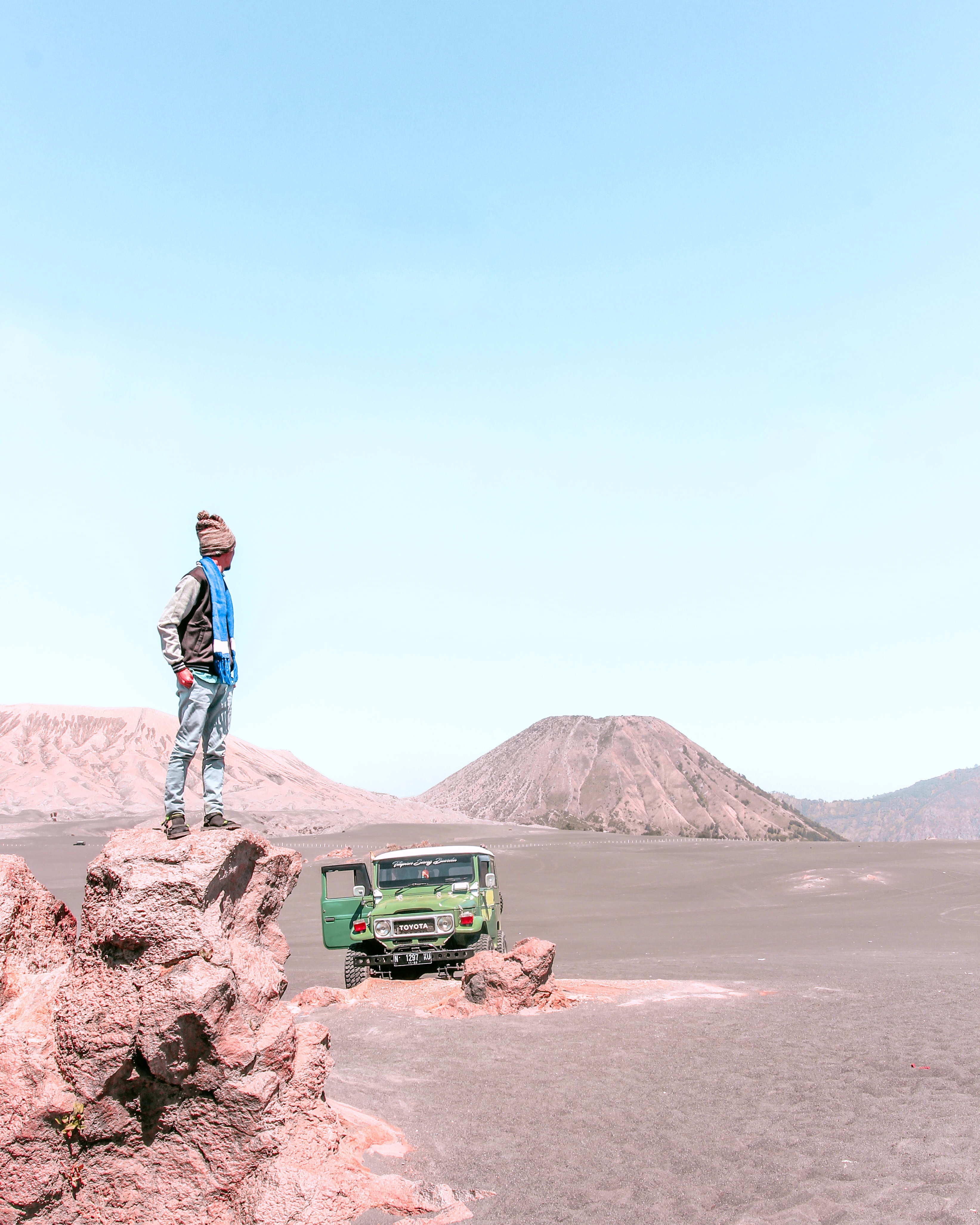 Man Standing on Top of Rock Near Parked Green Toyota Land Cruiser Fj40 · Free