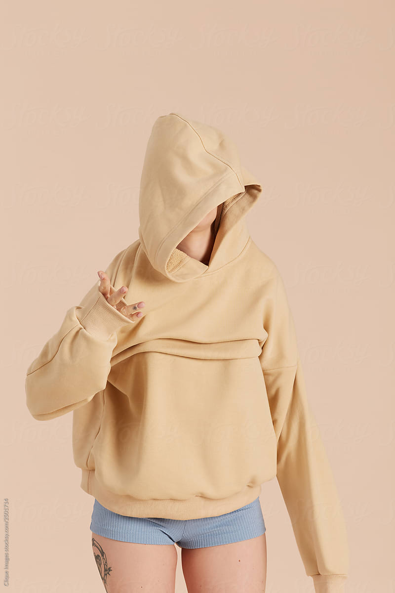 Female Model Putting On Hoodie by Clique Image, Clumsy