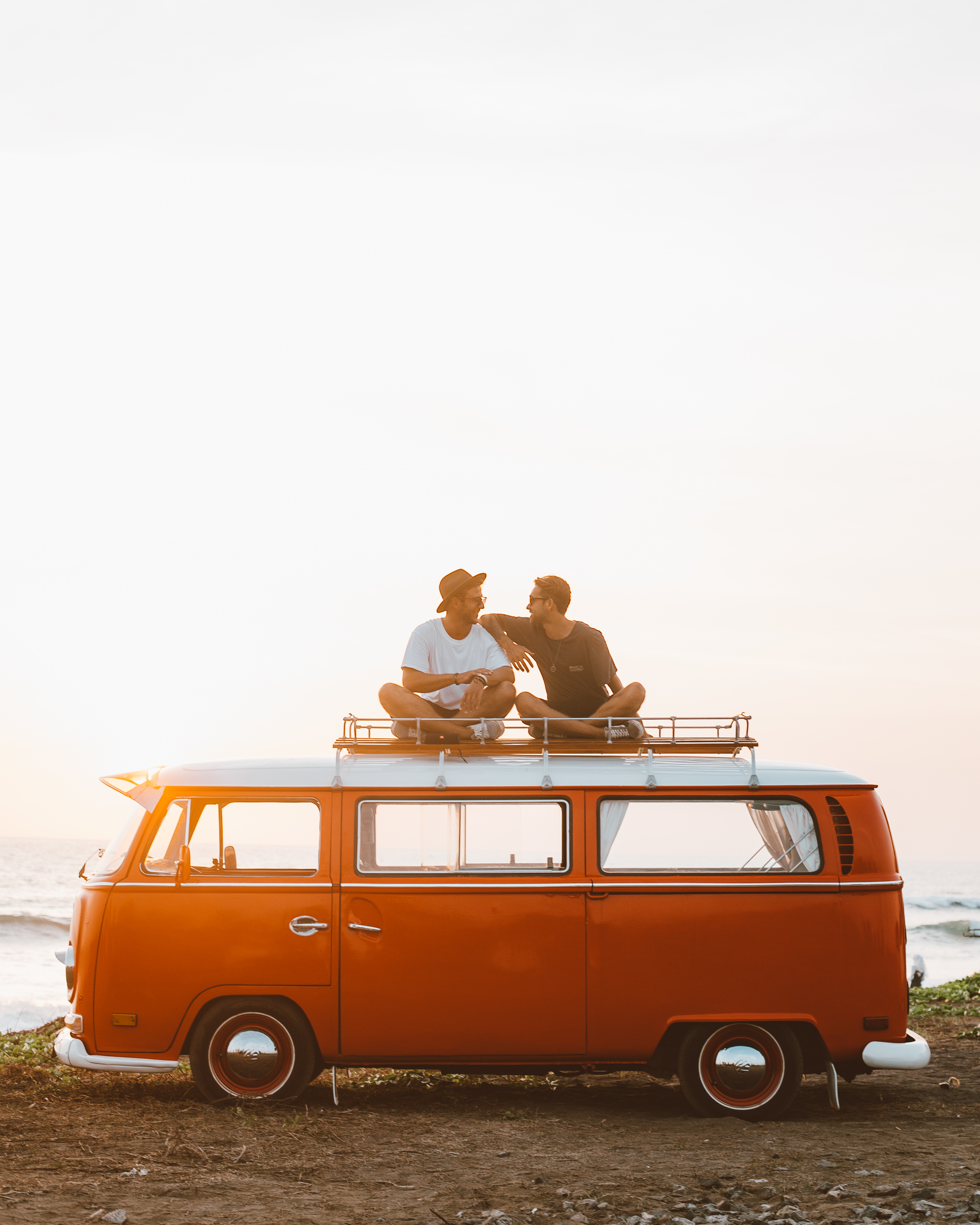 Happy friends on camper van roof · Free