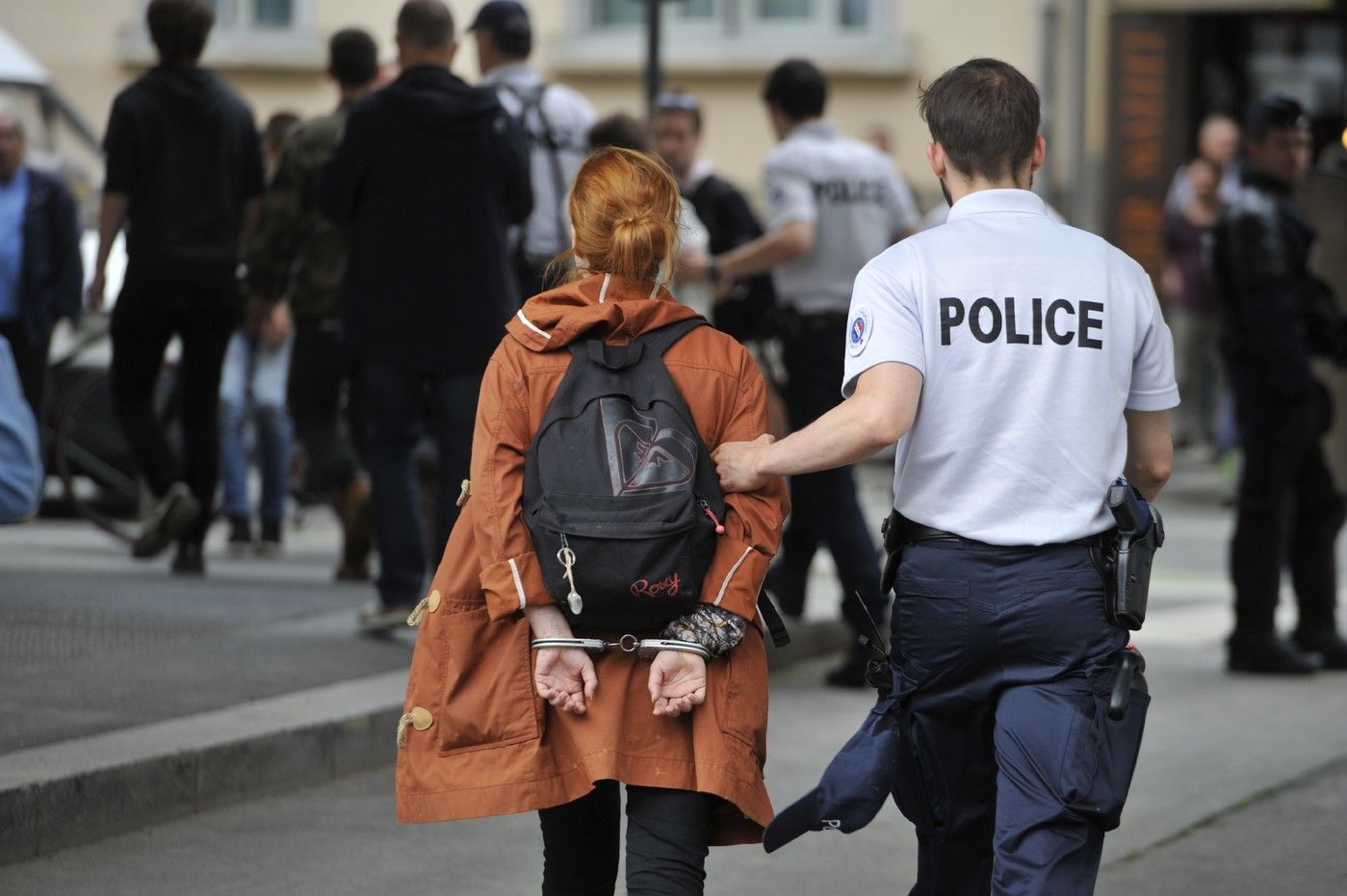 Woman arrested and handcuffed behind back in france. 