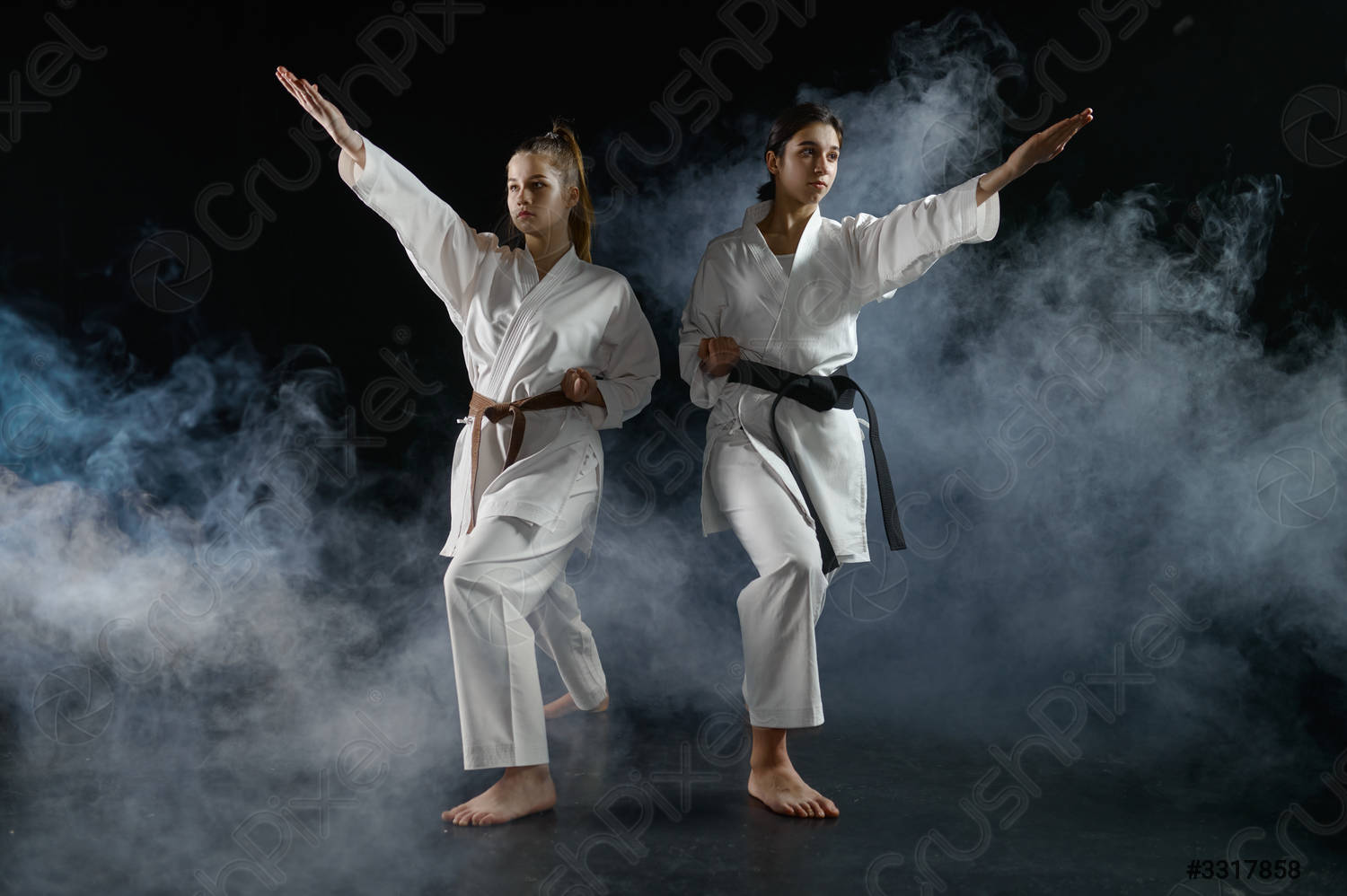 Female karatekas in kimono, combat stance