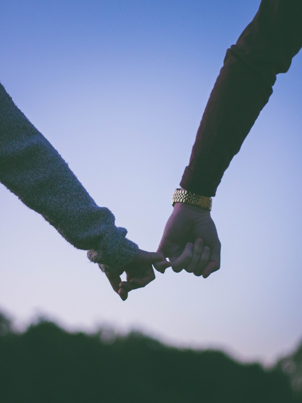 man and woman holding hand using pinky fingers photo