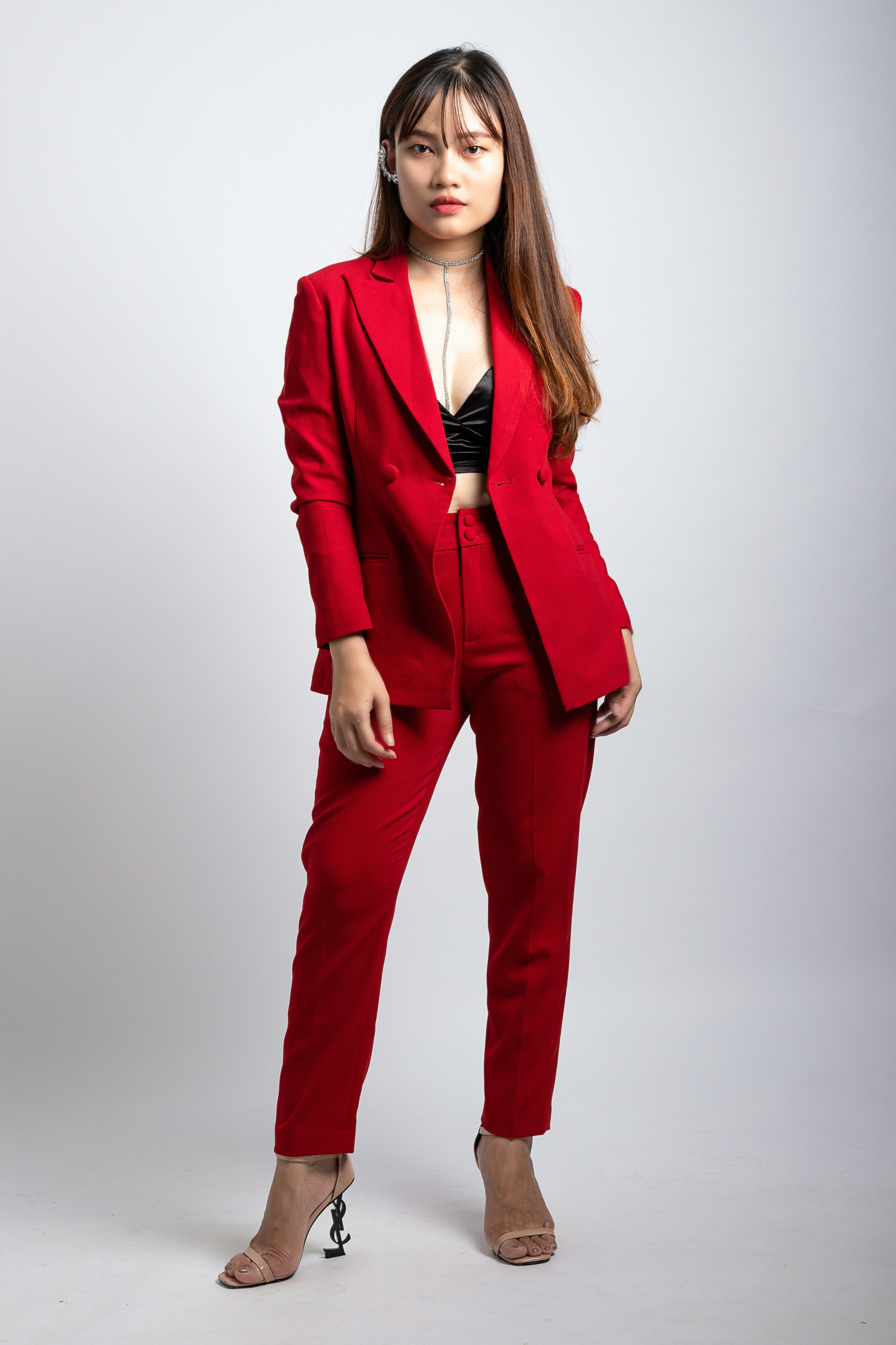 Woman Wearing Red Coat and Dress Pants Standing in Front of White Wallpaper · Free