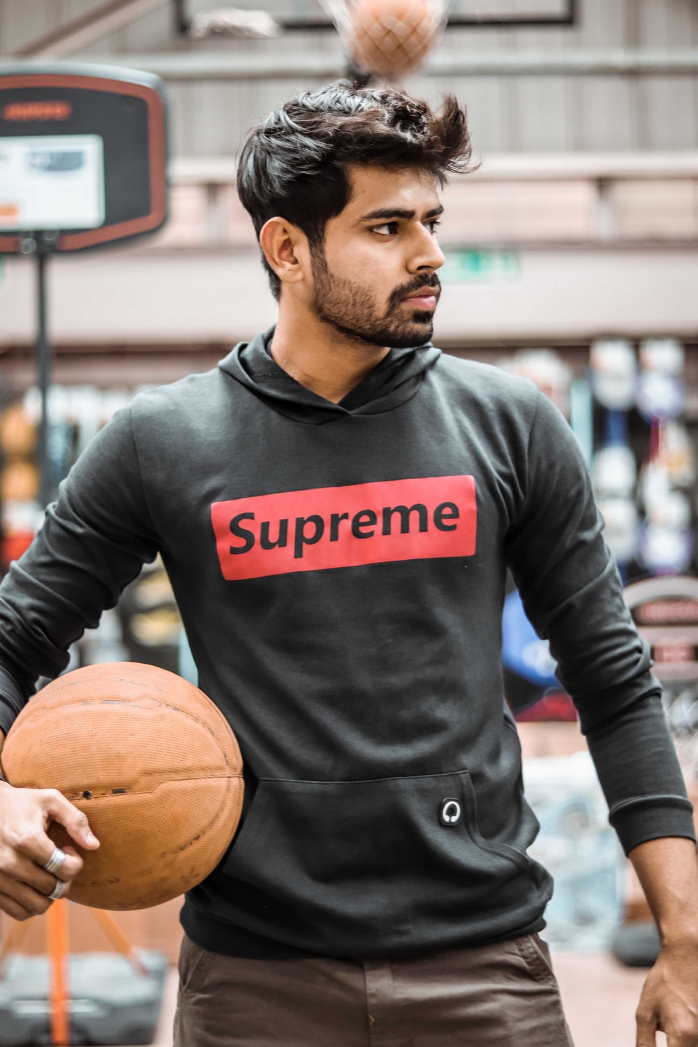 man in gray Supreme hoodie holding basketball photo