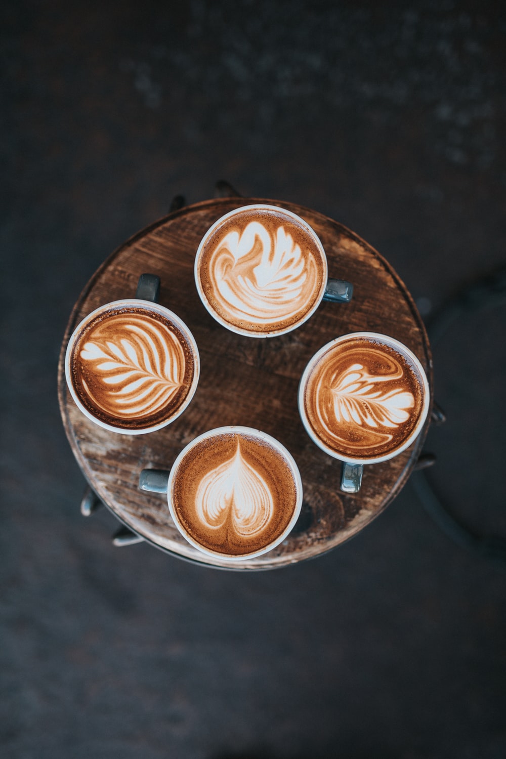 person holding cup of coffee pouring milk photo